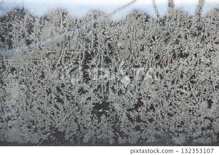 Patterns on the window in winter. Winter drawing on the window. Natural pattern 132353107