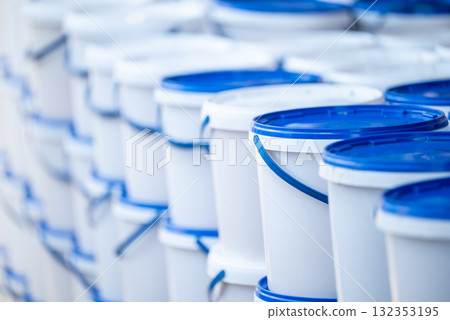 White and blue buckets with honey on apiary. Harvesting honey season, batch of buckets with ripe fresh honey White and blue buckets with honey on apiary. Harvesting honey season, batch of buckets with ripe fresh honey 132353195