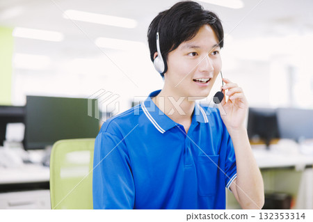 A man working in a call center wearing a headset A man working in a call center wearing a headset 132353314
