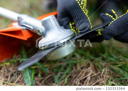 Gasoline grass trimmer after work. Maintenance of blades of grass mower Gasoline grass trimmer after work. Maintenance of blades of grass mower 132353364
