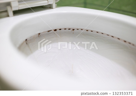 Dirt under the rim of toilet bowl. Close up view of dirty canals from which water flows in the lavatory pan during flushing Dirt under the rim of toilet bowl. Close up view of dirty canals from which water flows in the lavatory pan during flushing 132353371