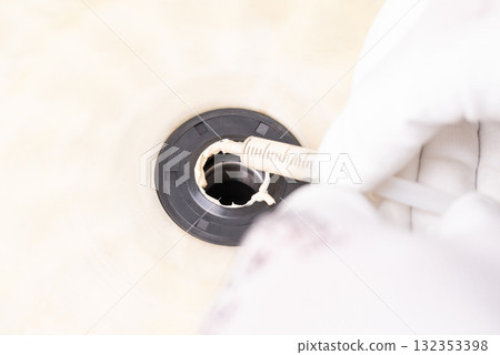 Applying sealant to rubber gasket for washing machine. Technician applies sealant on a rubber gasket while repairing a washing machine in a service center 132353398