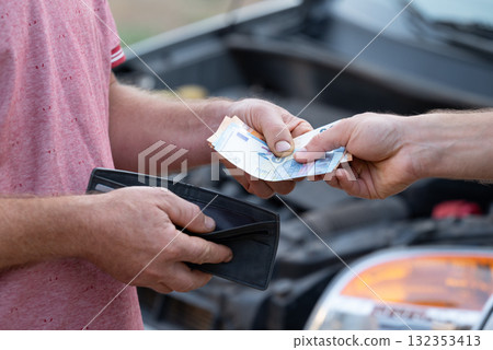 Spending all money for fixing car, high price for service and maintenance of vehicle. Car owner paying service mechanic at garage workshop for fixing broken down car 132353413