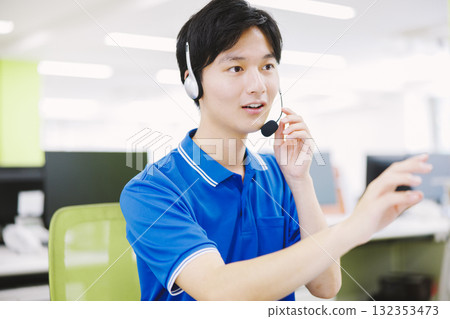 一名戴著耳機在呼叫中心工作的男子 132353473