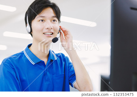 一名戴著耳機在呼叫中心工作的男子 132353475