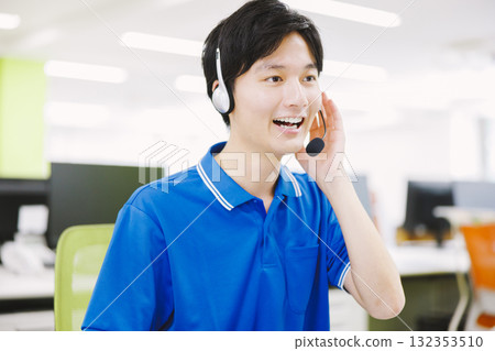 A man working in a call center wearing a headset 132353510
