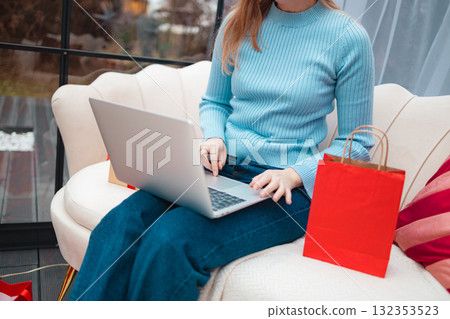 Woman shopping online for Christmas gifts using laptop Woman shopping online for Christmas gifts using laptop 132353523