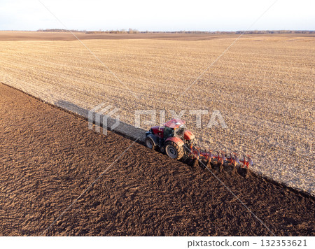 Aerial shot of tractor, ploughing field, made with drone. Farming, cultivating the land, machinery concepts 132353621