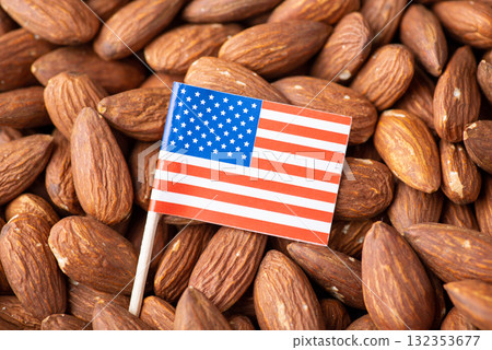 Small flag of USA on almond nuts. Trade of nuts concept, origin of almond Small flag of USA on almond nuts. Trade of nuts concept, origin of almond 132353677