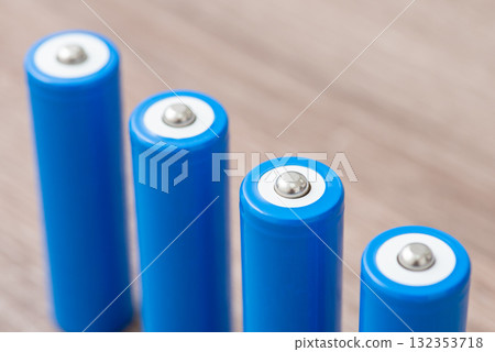 Close up of four blue 18650 batteries on the table. Rechargeable li-ion batteries ready for use 132353718