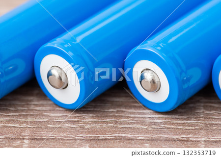 Close up of positive contact of rechargeable li-ion batteries. New high capacity batteries on the table Close up of positive contact of rechargeable li-ion batteries. New high capacity batteries on the table 132353719