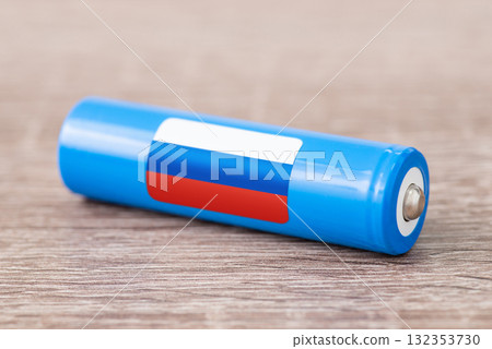 Rechargeable battery with flag of Russia on table. Origin of battery, produce accumulators in Russia 132353730