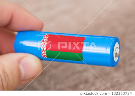 Rechargeable battery with flag of Belarus in hand of a man. Production of batteries in Belarus concept Rechargeable battery with flag of Belarus in hand of a man. Production of batteries in Belarus concept 132353734