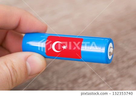 Rechargeable li-ion battery in hand of a man with sticker of Turkey flag. Produce lithium batteries in Turkiye Rechargeable li-ion battery in hand of a man with sticker of Turkey flag. Produce lithium batteries in Turkiye 132353740