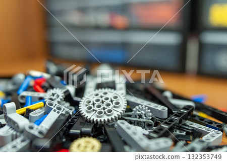 Close up on different parts of constructor on the table. Playing with developing constructor for boys and girls who want to create different mechanisms and machines Close up on different parts of constructor on the table. Playing with developing constructor for boys and girls who want to create different mechanisms and machines 132353749