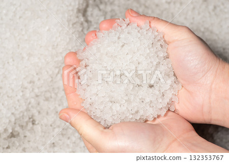 Girl holding much hail in hands. Hailstorm concept, everything covered in hail 132353767