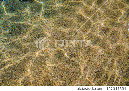 Transparent sea water revealing sandy seabed. Natural coastal scene with textured sand and calm water, perfect as a background, texture, or nature concept. Transparent sea water revealing sandy seabed. Natural coastal scene with textured sand and calm water, perfect as a background, texture, or nature concept. 132353864