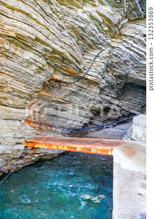 View from inside a coastal cave in Budva, Montenegro, showing an iron footbridge crossing the cave opening. Natural rock formations frame the scene with the Adriatic Sea visible outside. Perfect for View from inside a coastal cave in Budva, Montenegro, showing an iron footbridge crossing the cave opening. Natural rock formations frame the scene with the Adriatic Sea visible outside. Perfect for 132353869
