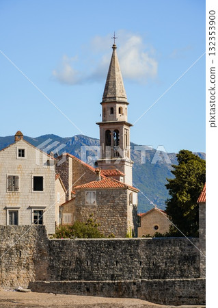 Close-up view of Budva Old Town and its historic tower from the waterfront. Detailed coastal cityscape with Adriatic Sea in the background. 132353900
