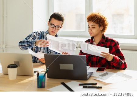 Teamwork brainstorm. Diverse colleagues working together discuss financial statistics. Group of happy young modern people sitting in creative office discussing business. Young professional team 132354093