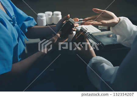 Female doctor holding a medicine bottle is checking the quality of medicine for any side effects the patient or not and recording patient information at the hospital. medical and health care concept 132354207