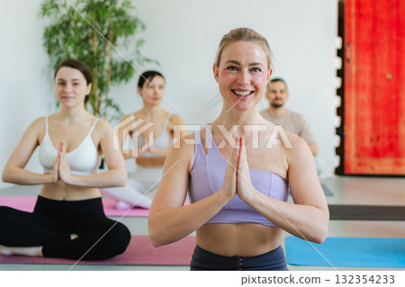 Yoga mindfulness meditation. Group of sporty people doing exercise in studio for class for yoga wellness mindfulness meditation. Men women practicing yoga sitting in lotus pose meditating relaxing 132354233