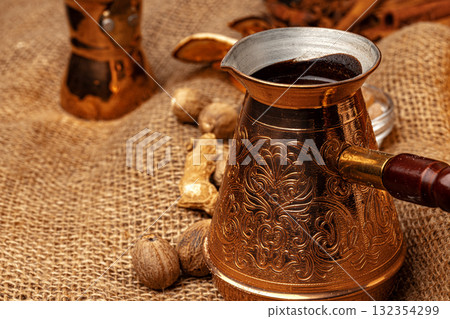 Shiny copper turk with brewed coffee on brown wooden table Shiny copper turk with brewed coffee on brown wooden table 132354299