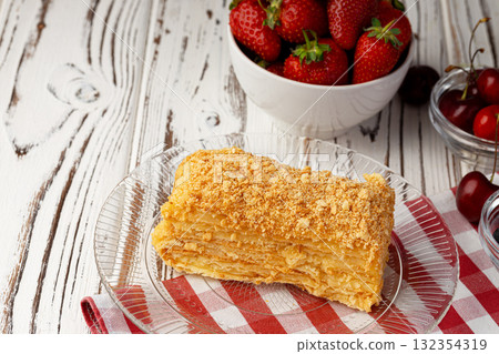 Piece of russian honey cake medovik served with berries 132354319