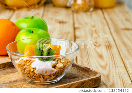 Bowl of granola with youghurt and sliced fruits Bowl of granola with youghurt and sliced fruits 132354352