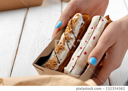 Fresh eclair cakes in a cardboard box Fresh eclair cakes in a cardboard box 132354362