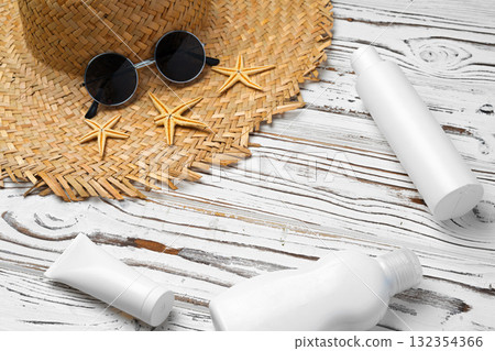 Straw hat, sunglasses and sunscreen bottle on wooden background 132354366