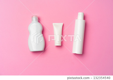 Three white cosmetic bottles on pink background flat lay Three white cosmetic bottles on pink background flat lay 132354540