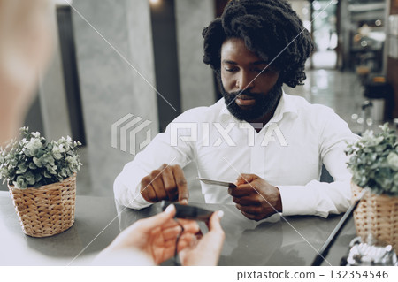 African man businessman paying for the stay in hotel with credit card 132354546
