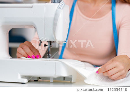 Woman seamstress working at textile factory close up Woman seamstress working at textile factory close up 132354548