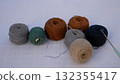 Many skeins with cotton crochet threads on the table in brown-gray tones.  132355417