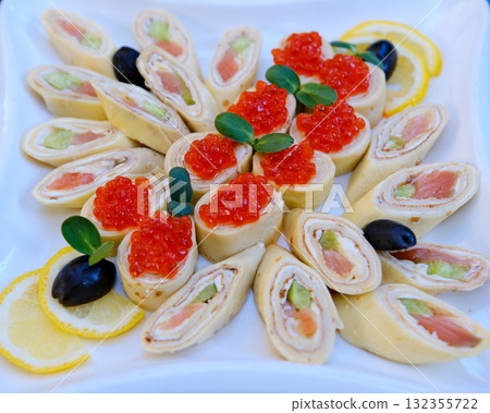 Pancake salmon rolls of thin pancakes with smoked salmon, horseradish cream cheese and rocket leaves Pancake salmon rolls of thin pancakes with smoked salmon, horseradish cream cheese and rocket leaves 132355722