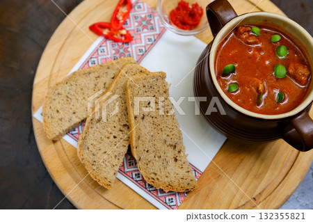 Bread soup peppers Tomato soup with basil in a bowl. Dark background. Copy space. Top view. Bread soup peppers Tomato soup with basil in a bowl. Dark background. Copy space. Top view. 132355821