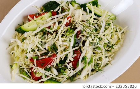 Vegetarian salad. Spring vegan salad with cabbage, cucumber, green onion and parsley. Top view, flat lay, overhead Vegetarian salad. Spring vegan salad with cabbage, cucumber, green onion and parsley. Top view, flat lay, overhead 132355826
