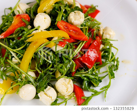 Fresh salad with arugula, mozzarella, tomatoes and avocado in a bowl. Healthy vegetarian dish Fresh salad with arugula, mozzarella, tomatoes and avocado in a bowl. Healthy vegetarian dish 132355829