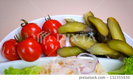 pickled tomatoes, cucumbers and cabbage on a plate Set of chopped fermented pickles, clay brown bowl. Collection of homemade salty appetisers made of vegetables placed on straw stand. pickled tomatoes, cucumbers and cabbage on a plate Set of chopped fermented pickles, clay brown bowl. Collection of homemade salty appetisers made of vegetables placed on straw stand. 132355830