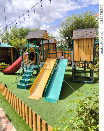 Children's playground with slides and wooden houses in the open air 132356265