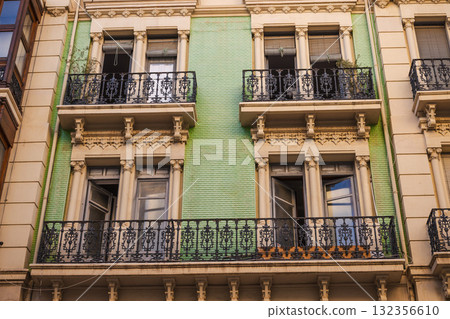 Historic Art Nouveau facade with decorative balconies and green ceramic tiles in Alicante, Spain 132356610