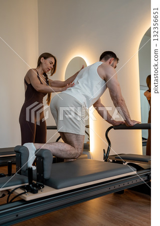 Instructor guides posture correction, Calm atmosphere with handson guidance for posture improvement 132356651