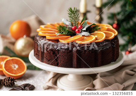 Chocolate cake decorated with orange slices and festive greenery for winter holiday celebration Chocolate cake decorated with orange slices and festive greenery for winter holiday celebration 132356855