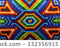 An extreme close-up, macro shot of a brightly coloured piece of intricate beadwork or mosaic, consistent with traditional Huichol art from Mexico. 132356915