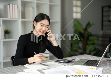 Young woman discussing financial matters on phone while managing tax payments Young woman discussing financial matters on phone while managing tax payments 132357107