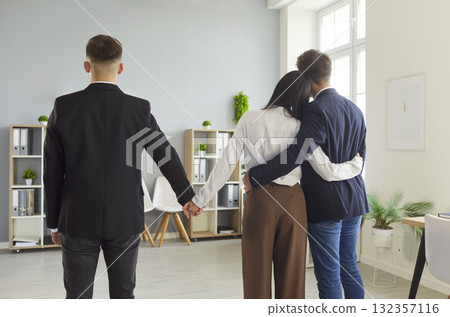 Infidelity concept: partner embraces lover as hidden handhold betrays commitment 132357116