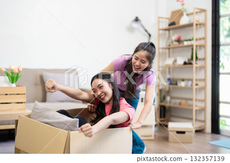 Playful adventure A lesbian couple enjoying a moving box ride Playful adventure A lesbian couple enjoying a moving box ride 132357139