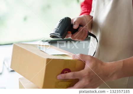 Inventory management with employee scanning packages using barcode scanner 132357185