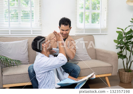 Planning and Fun. A couple playfully interacting while reviewing their travel plans. Planning and Fun. A couple playfully interacting while reviewing their travel plans. 132357198